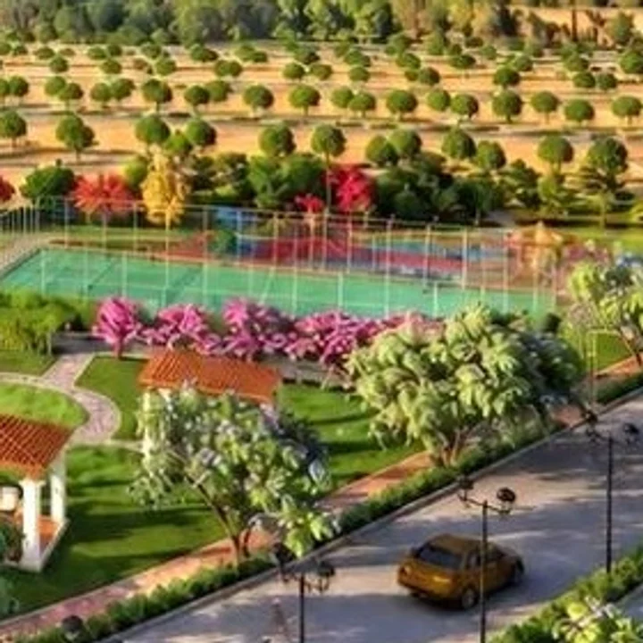 Prestige Chapparakallu Road second court behind a bank of pink blossom in the launch render
